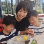 母と二人の子どもが「Buon Compleanno」のメッセージ入りデザートプレートを囲んで微笑む様子