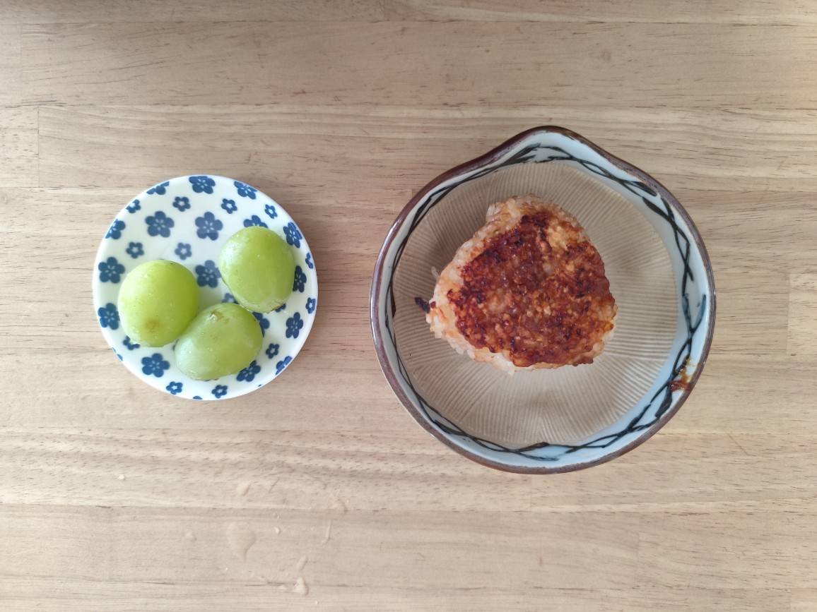 焼きおにぎりとシャインマスカットが並んだ朝ごはん。