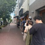 蒲田の名店「鳥久」の店舗前に並ぶ人々。歩道には長い行列ができており、人気の高さがうかがえる。