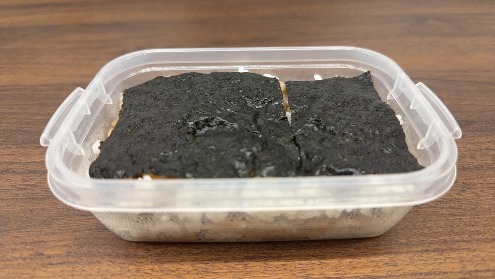 透明なタッパーに詰められたご飯の上に、海苔を敷き詰めたシンプルなお弁当。横須賀では「海苔だんだん」、川崎では「海苔弁」と呼ばれる。