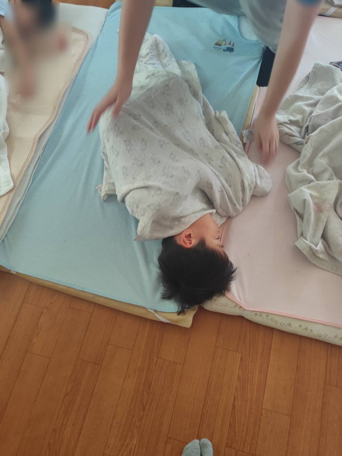 布団にくるまれてミノムシのように眠る子どもの可愛い寝顔。