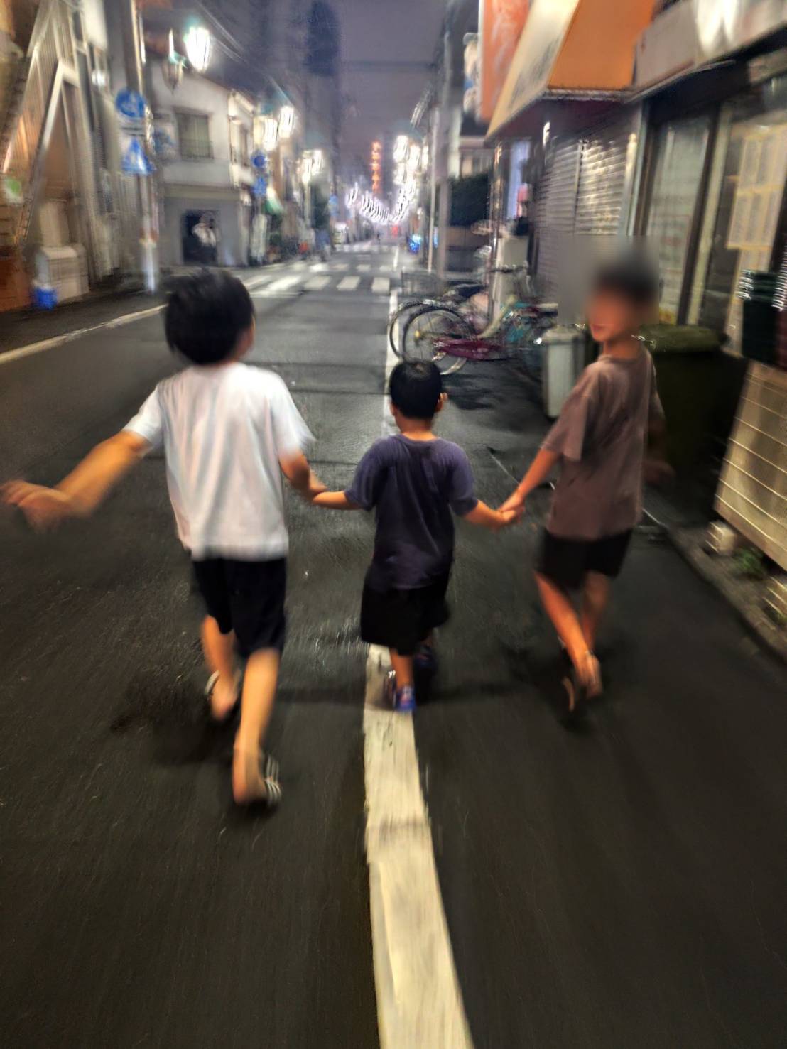 お泊まり会の夕食を囲む子どもたちと、夜の街を手をつないで歩く3人の後ろ姿。