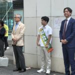 川崎駅前で市議会議員選挙の応援活動を行う様子。マイクを手に挨拶する人々と支援者の姿。