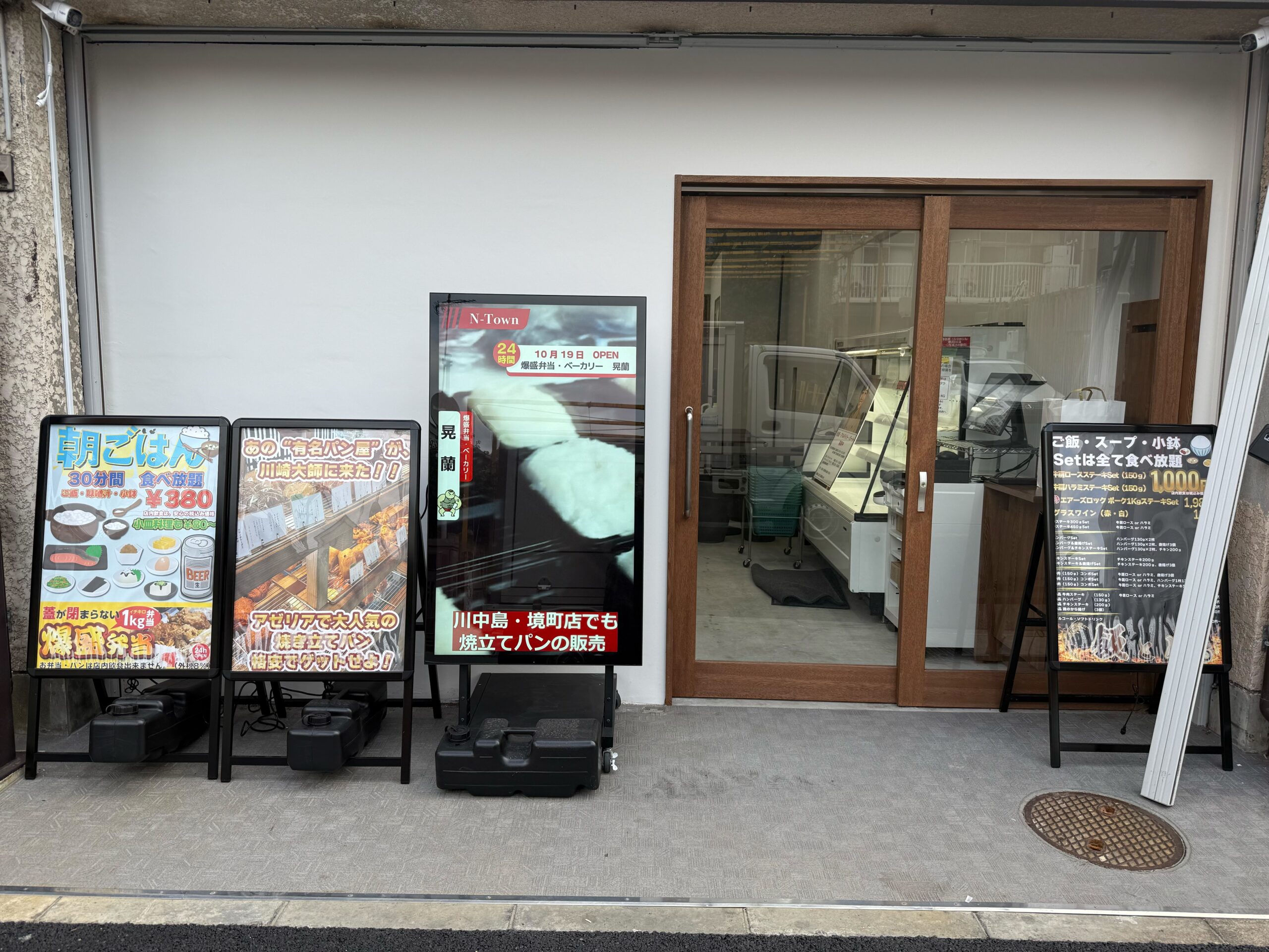 「飯と肉。」店舗外観写真。2025年10月19日18時よりグランドオープン。ステーキ・ご飯・小鉢・汁物が食べ放題。爆盛弁当&ベーカリー晃蘭も同時オープン。