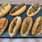 川崎大師店で販売中の新作お惣菜コッペパン。焼きそば、ナポリタン、白身フライ、メンチカツなど、ボリューム満点の7種類。