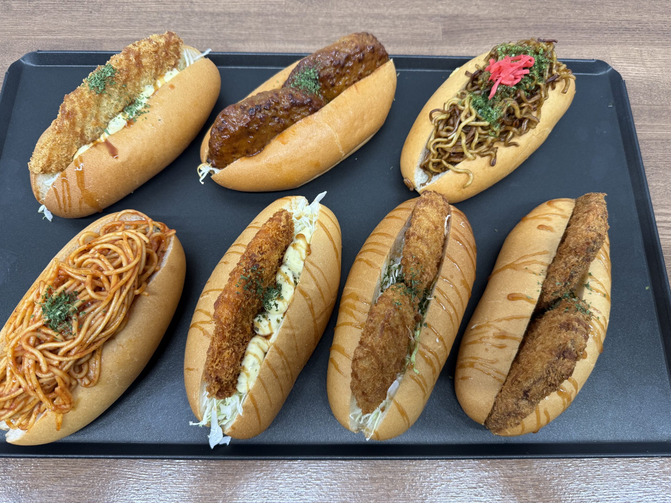 川崎大師店で販売中の新作お惣菜コッペパン。焼きそば、ナポリタン、白身フライ、メンチカツなど、ボリューム満点の7種類。