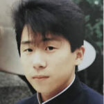 「父の18歳頃の若い日の写真。制服姿のあどけない表情の少年が写っている。」