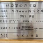 N-Town株式会社の建設業許可票を金色の額縁に入れて撮影した写真