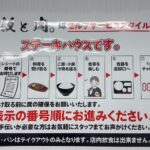 飯と肉。のセルフサービスの流れと番号呼び出し方法を説明した店内ポスターの写真