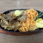 鉄板の上に盛り付けられた豚の生姜焼きとナポリタン、ポテトとインゲンのプレートの写真